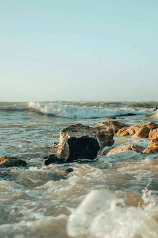 a po of a girl standing on a rock near the ocean