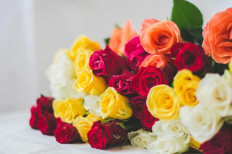 a bouquet of colorful roses sitting on top of a table