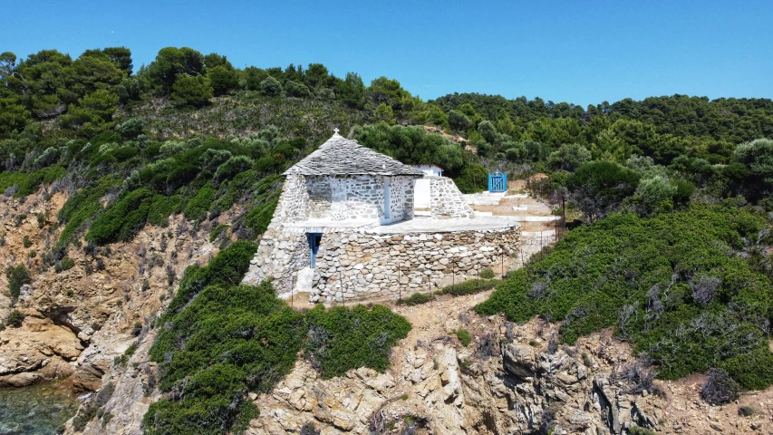 a small house on a hill near a body of water