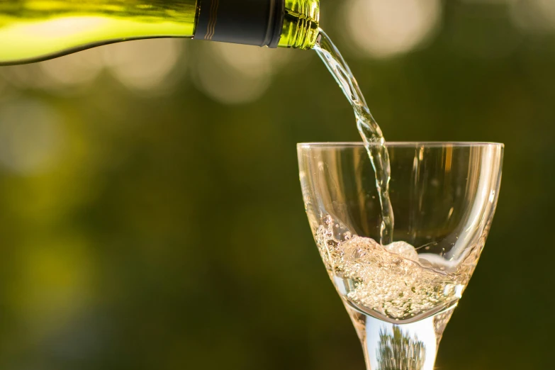 a person pours wine into a glass