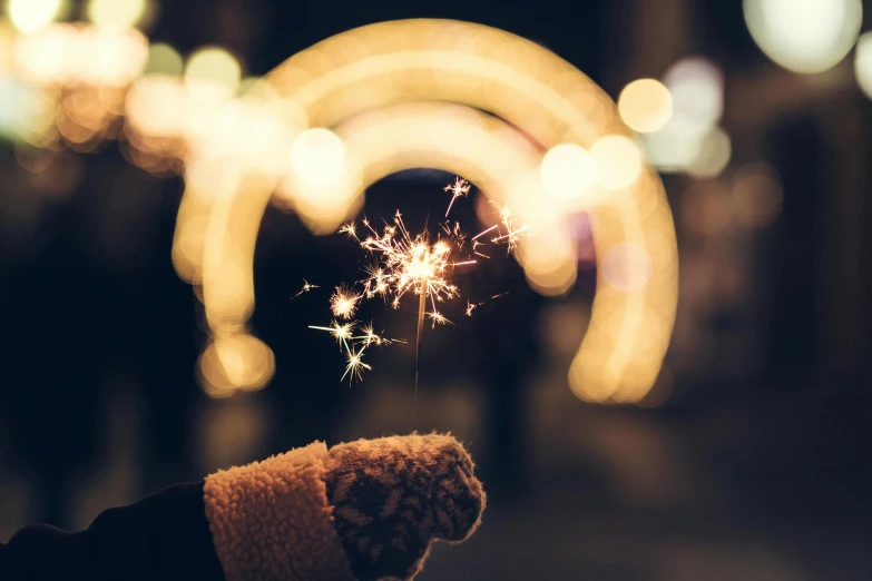 a person holding up a sparkler in front of them