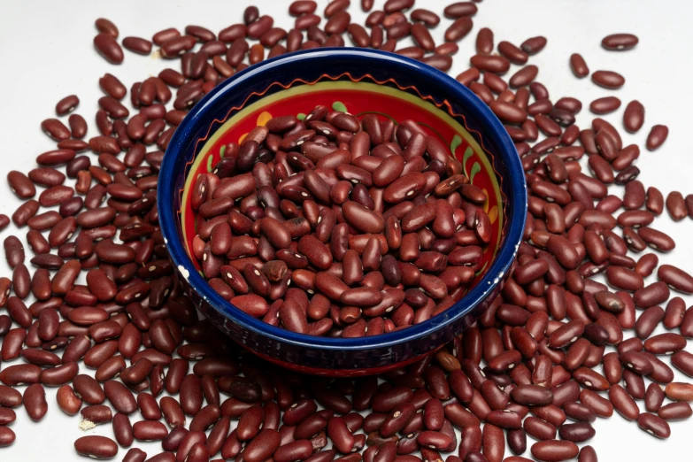 a bowl filled with beans is sitting on a table