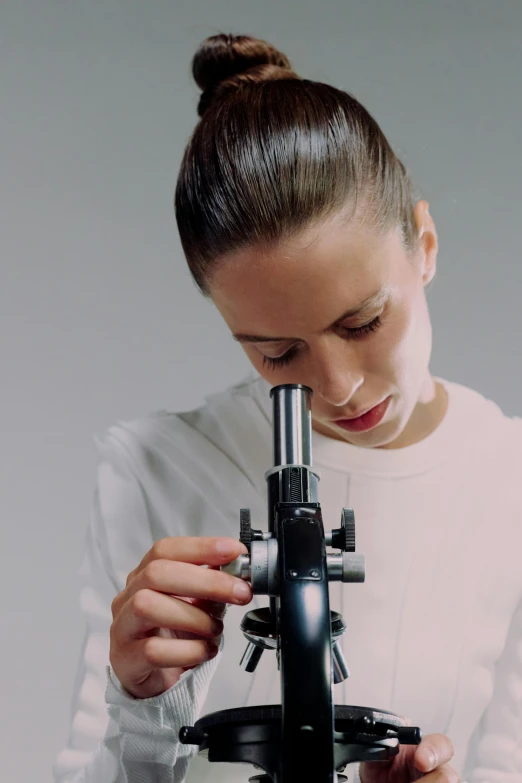 the woman is looking through the microscope