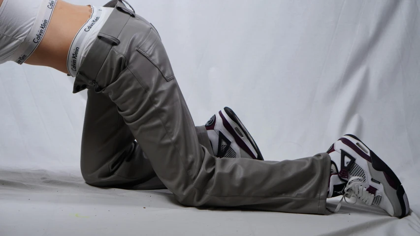 a woman is laying on the floor wearing grey pants