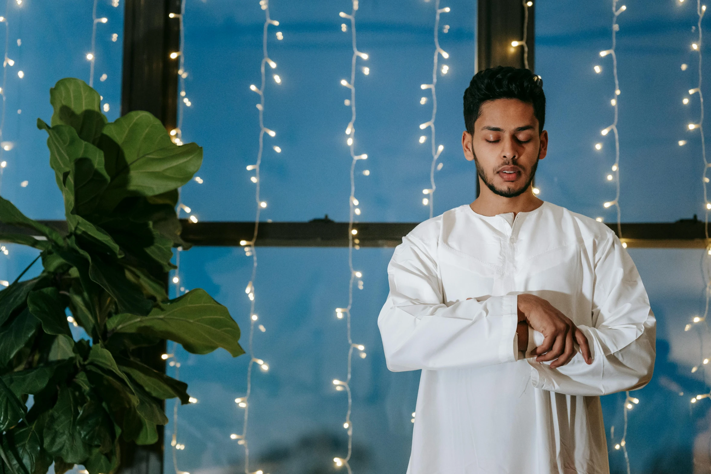 a man that is standing with his hands folded in front of him