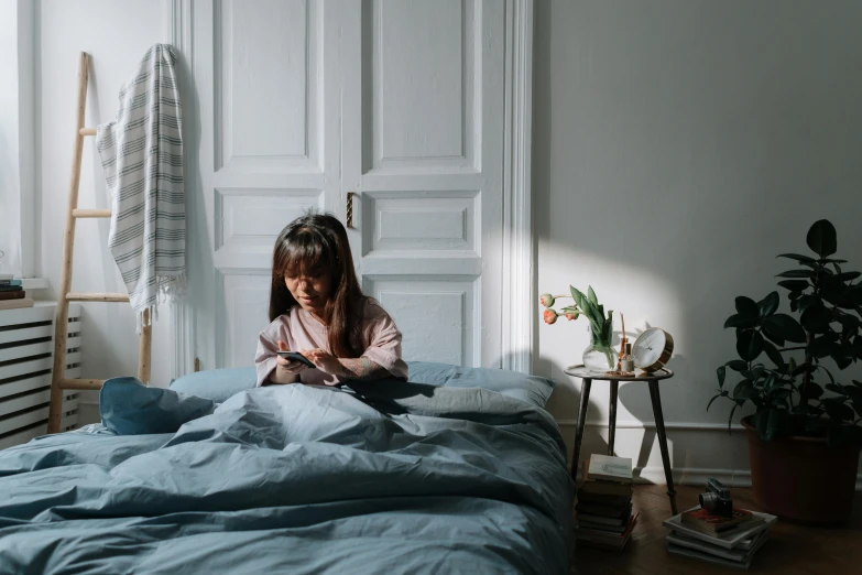 the girl is lying on a bed with sheets