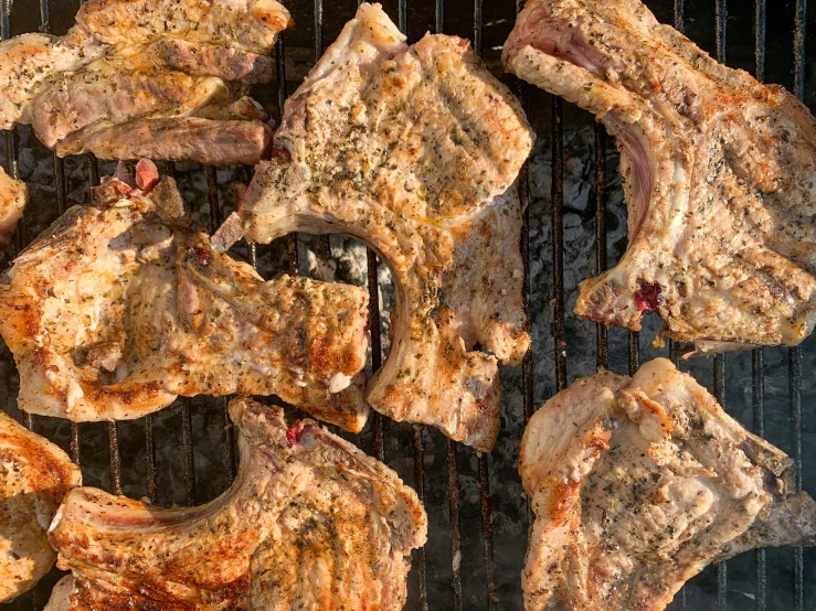 various meats being cooked on the grill outdoors