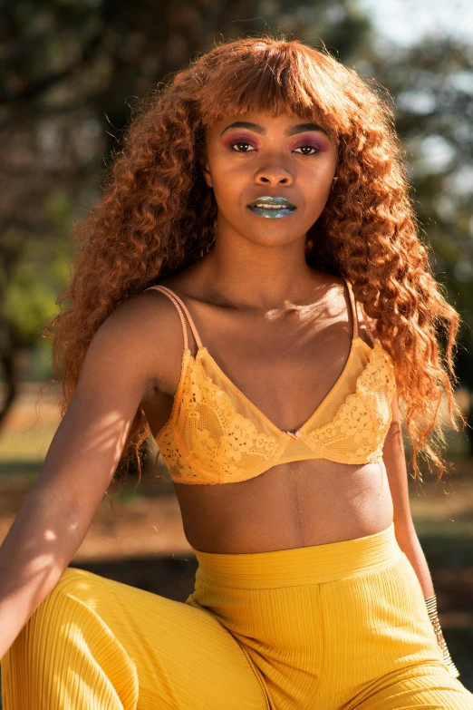 woman with curly hair and piercings sitting down