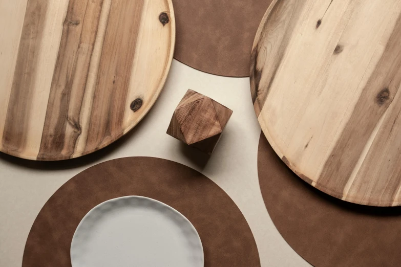 various wooden plates and cups sit on the ground