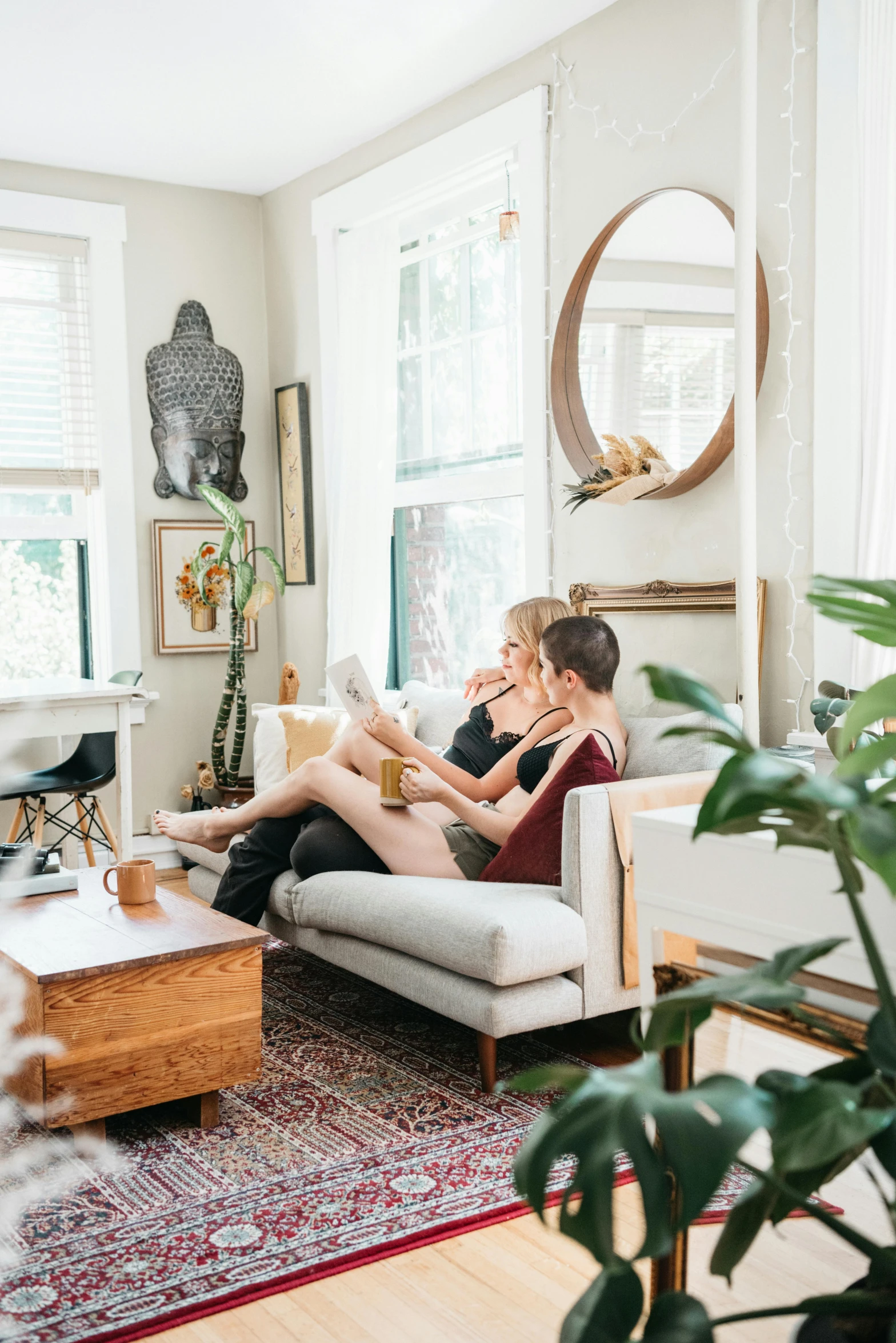 the two women are sitting on the couch