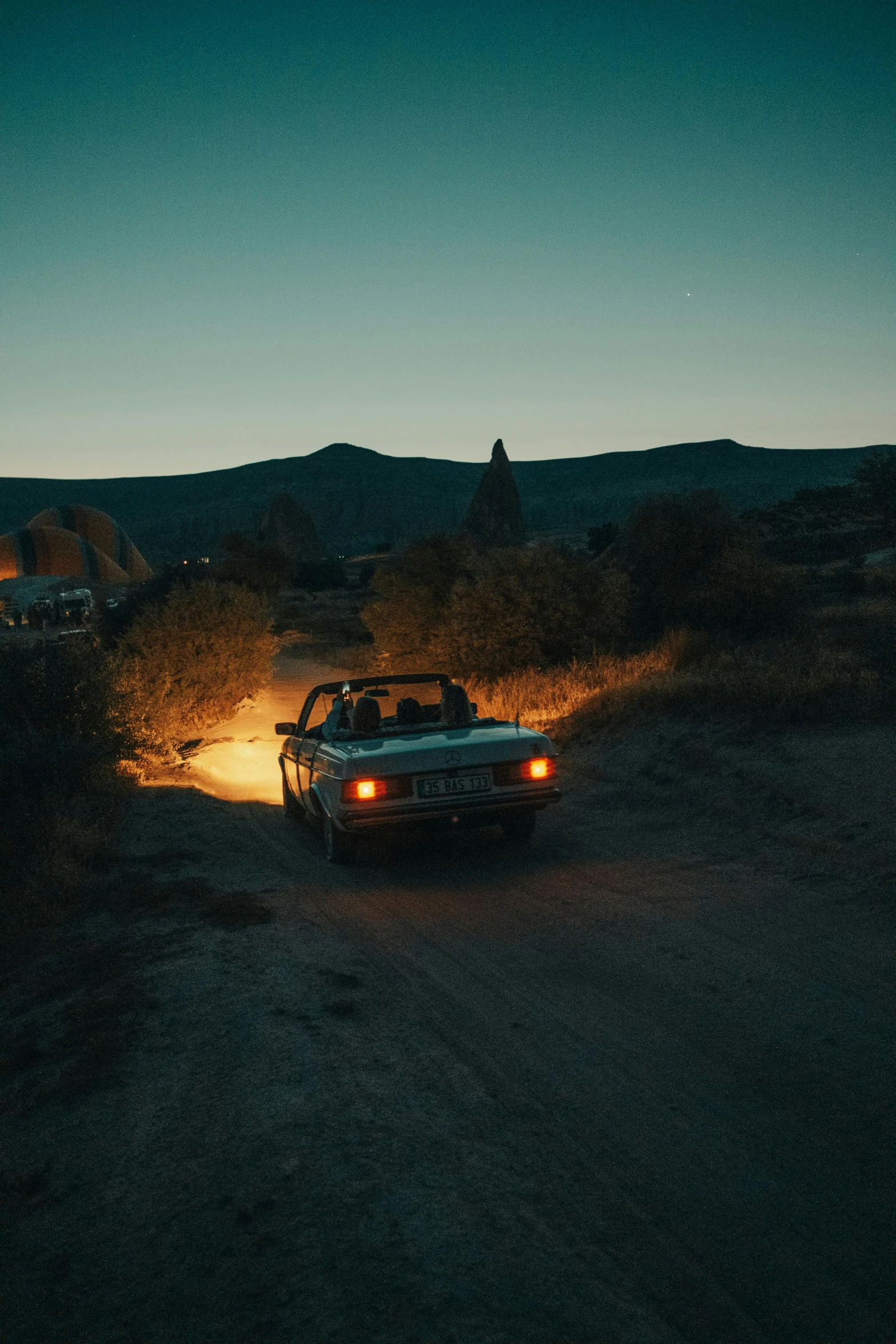 a car sits in the middle of a road with a person sitting behind it