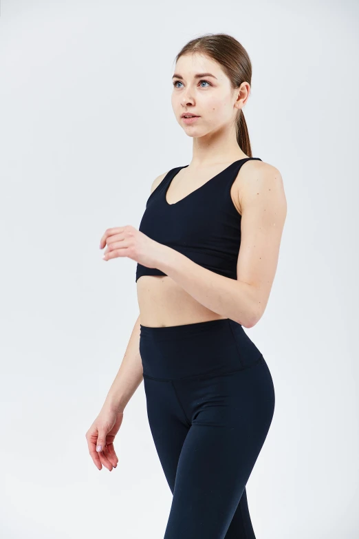 the woman in black yogawear is posing