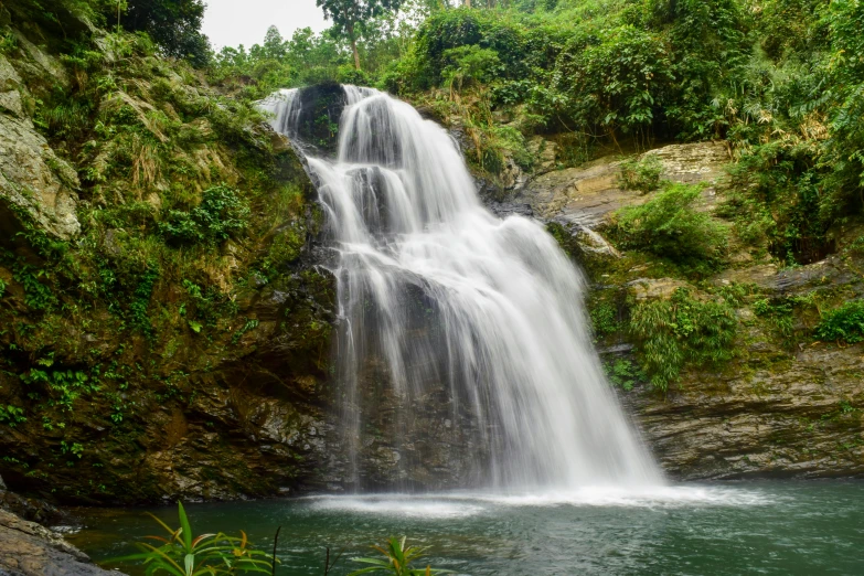 a long waterfall cascades down a mountain side