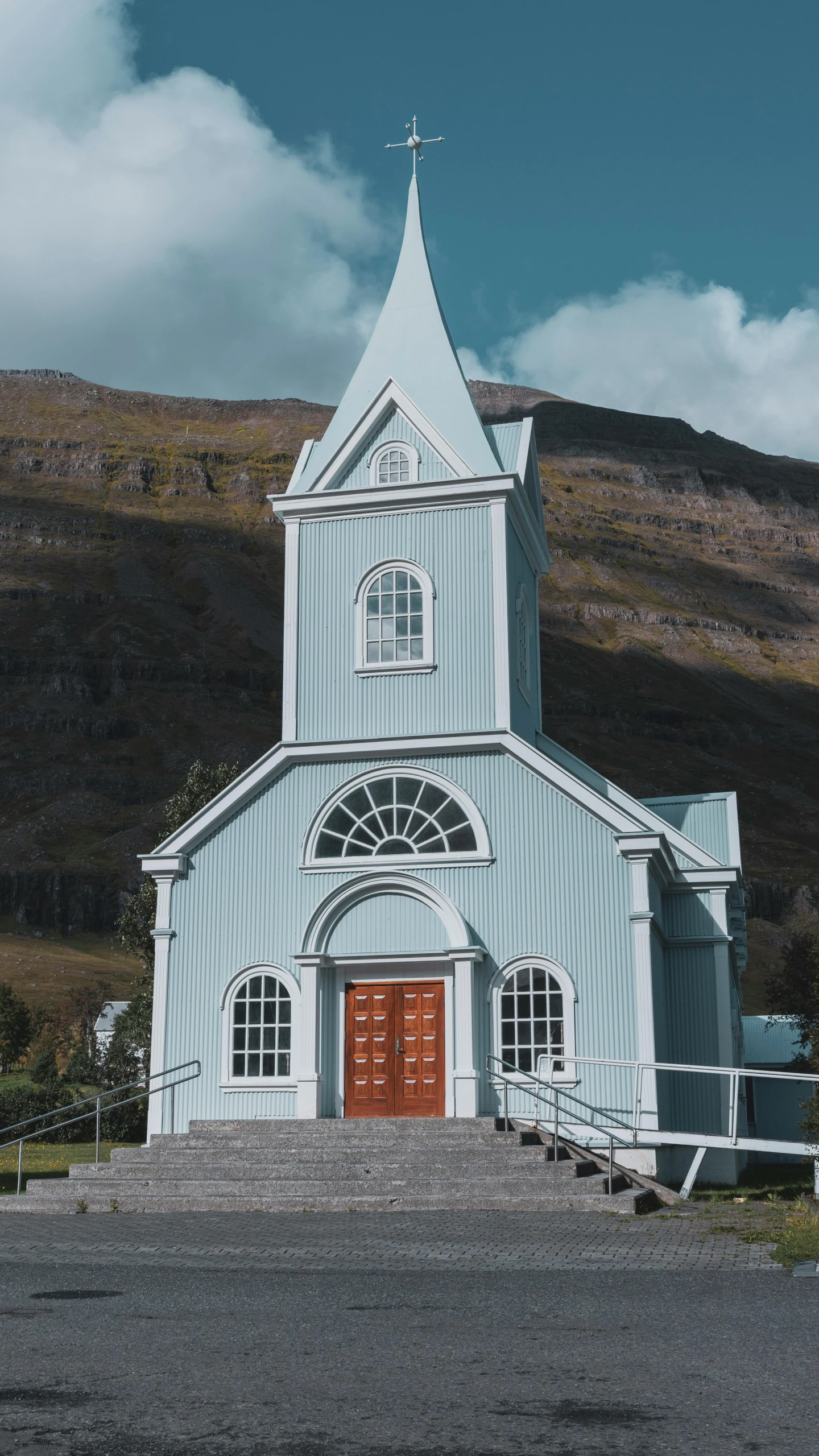 a church on a hill with mountains behind it