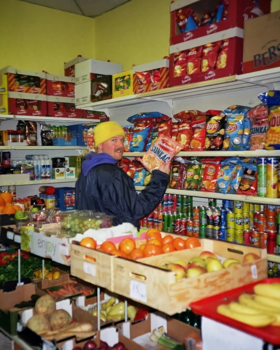 a man shopping in a store filled with fruit