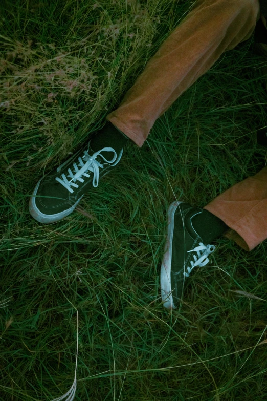 man standing in the grass with an odd green shoe