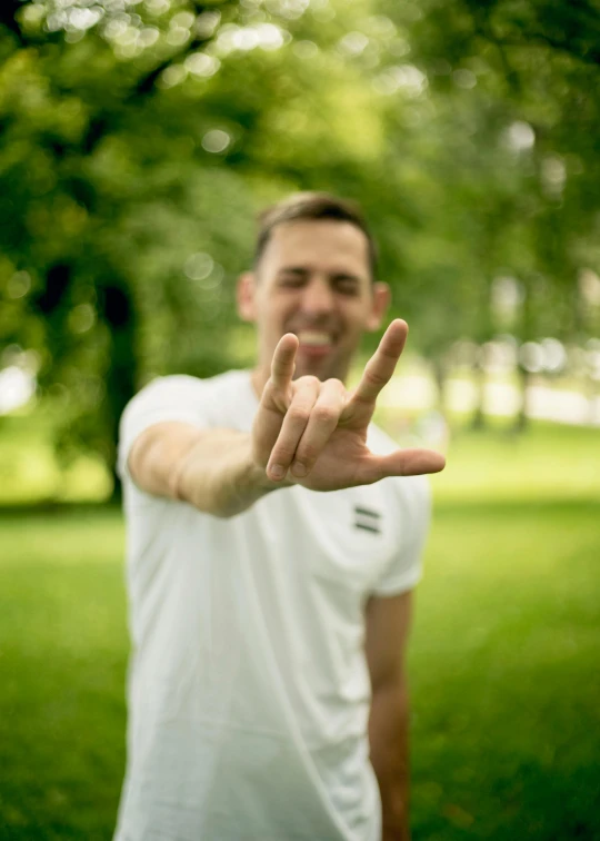 a man smiles as he poses in a park