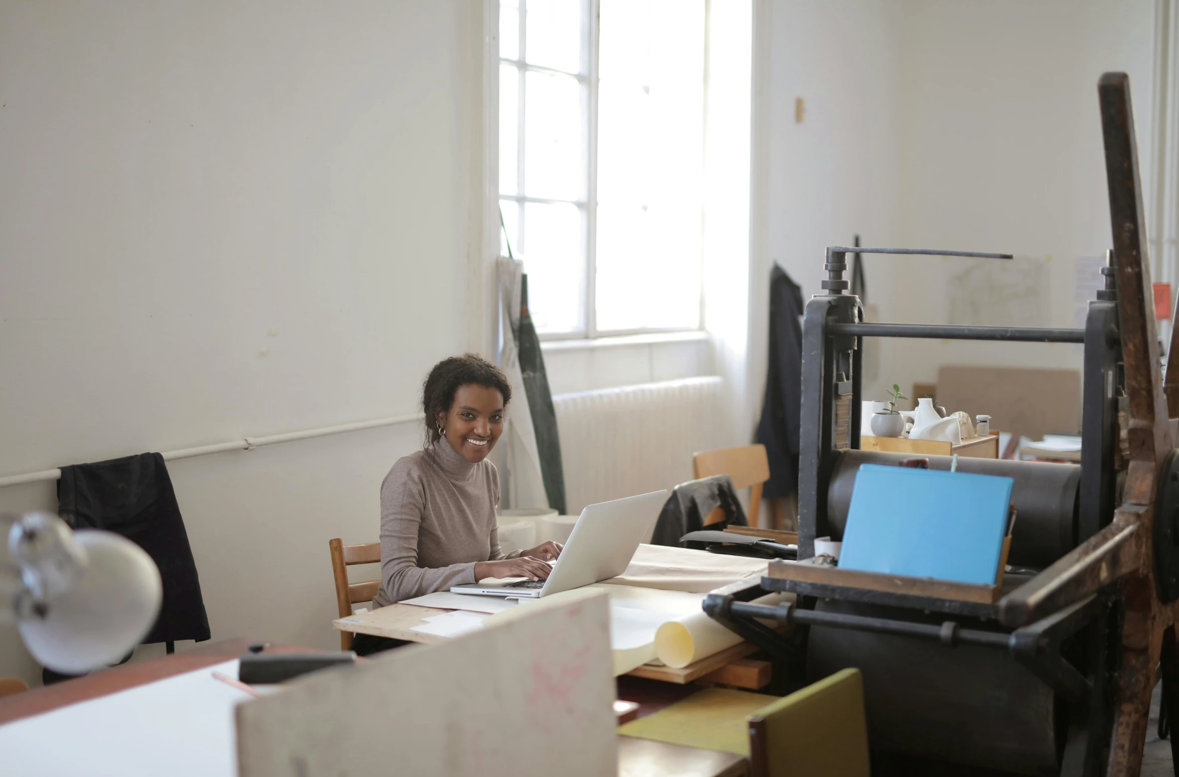 a woman on her laptop in an art studio