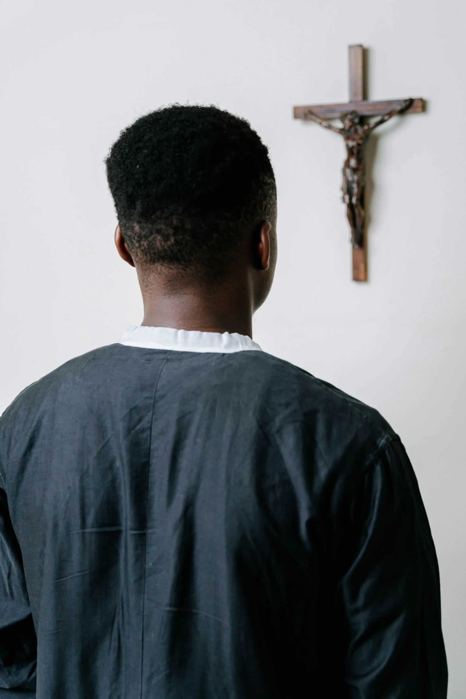 man standing in front of cross with crucifix