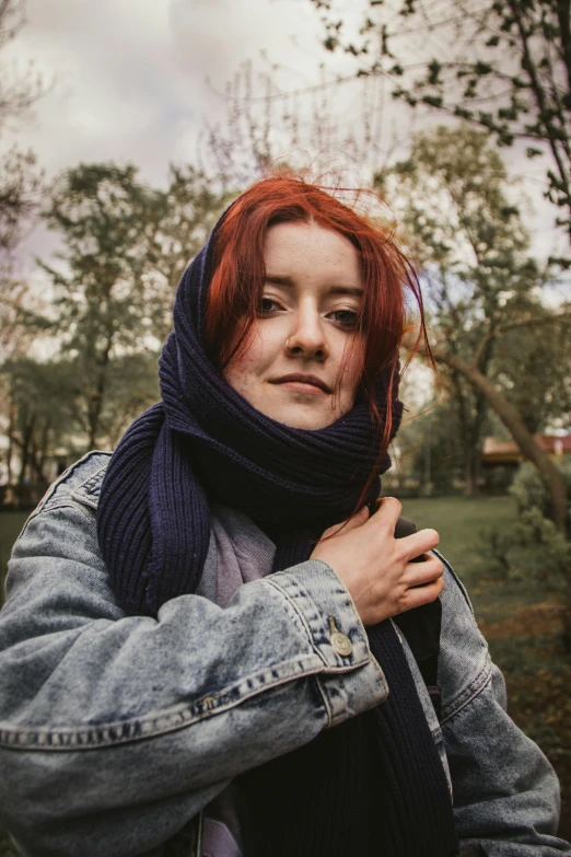 a woman is wearing a scarf and jeans jacket