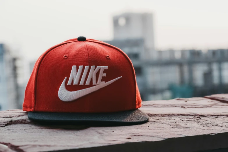 a red and white hat sitting on top of a brick wall