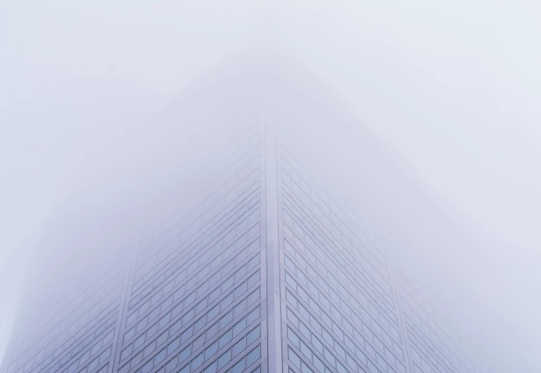 an office building is shown from the bottom in the fog