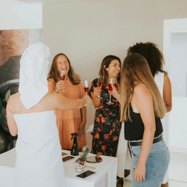 people standing around and drinking wine in a room