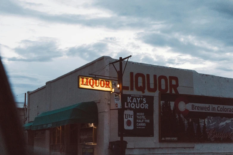 a liquor store is lit up at night time