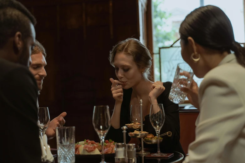 a woman in a black dress and man in white are sitting at a table