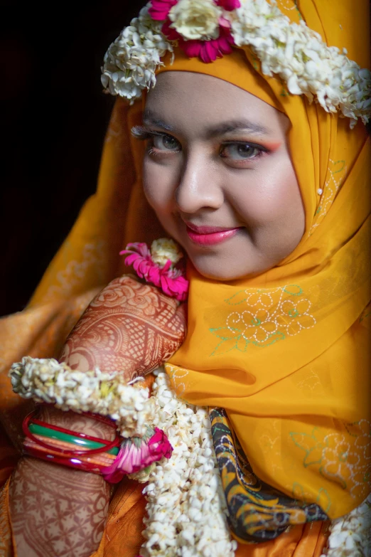 a girl wearing a yellow headdress with her hands covered
