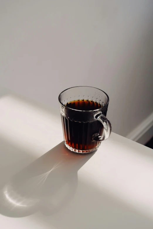 a cup filled with liquid sitting on top of a white table