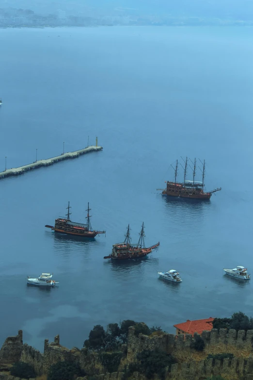 some boats sailing near a dock in a large body of water