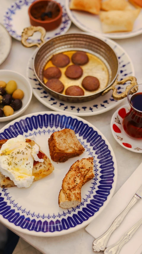 a white table topped with plates of food and silverware