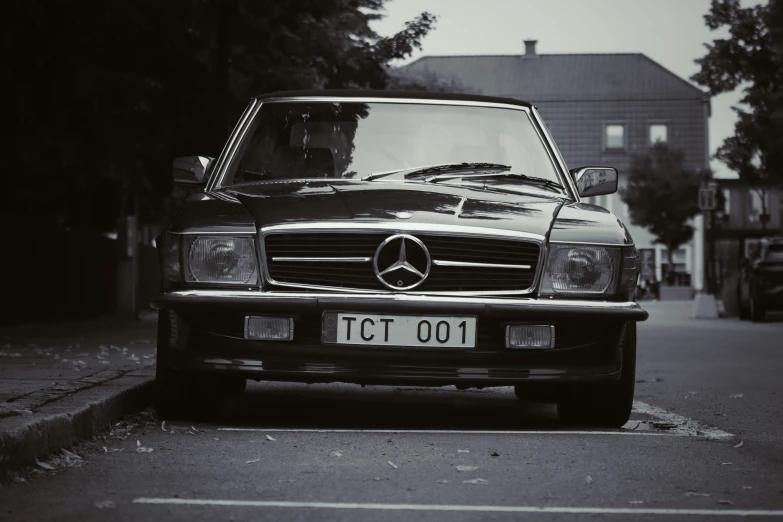 a mercedes is parked on the side of a street