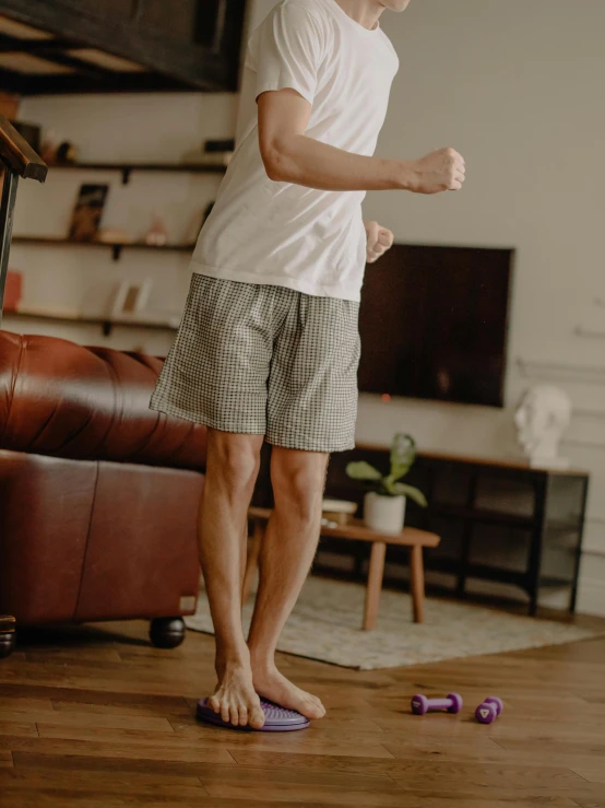 a man standing on a floor in front of a flat screen television