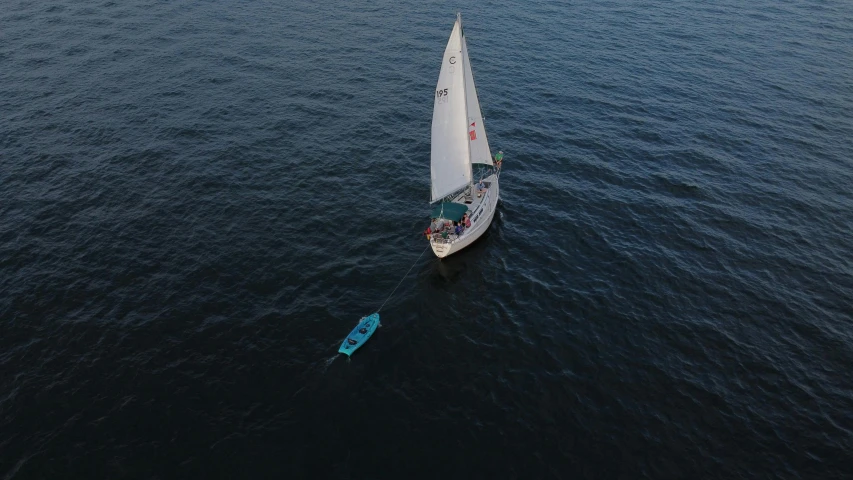 an aerial view of the sail boat in the water