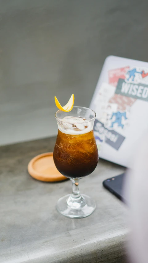 an old fashioned drink with a slice of orange is sitting on the table