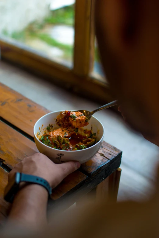 a bowl filled with some kind of food next to a window