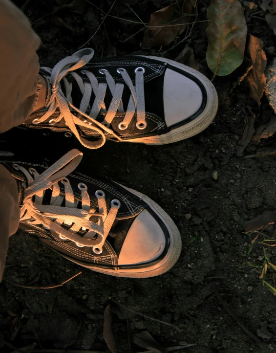 the bottom of two black sneakers, with one worn