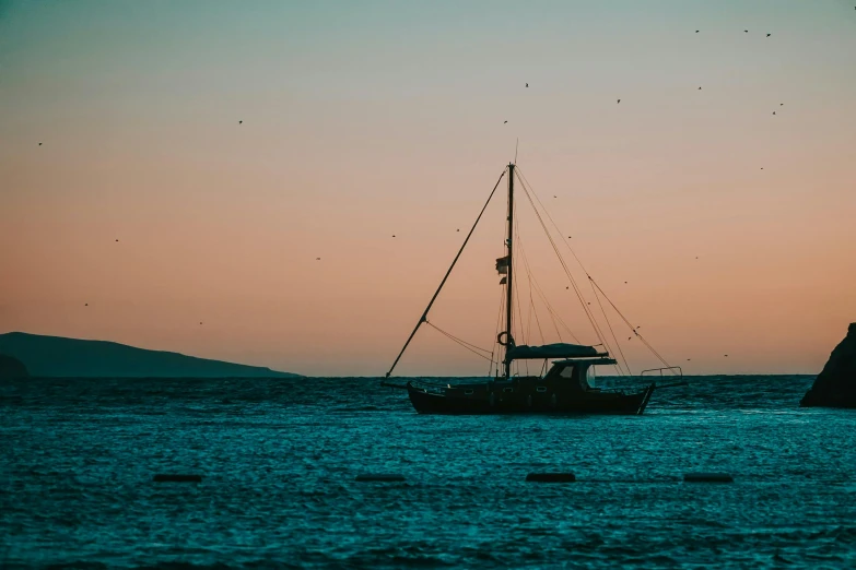 there is a boat sailing near shore at twilight