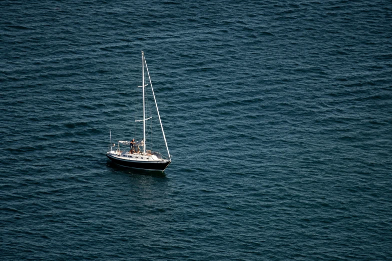 a sailboat floating in the ocean on a clear day