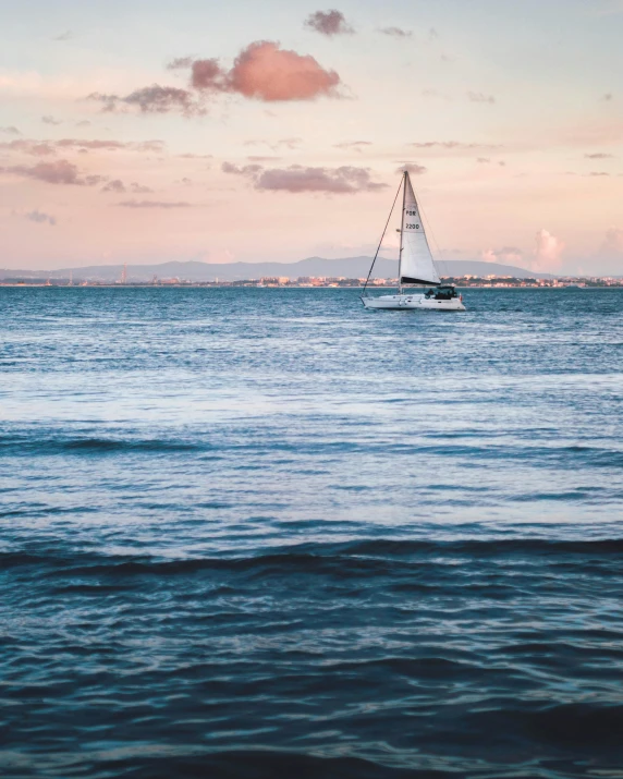 sail boat in calm ocean against dusk sky