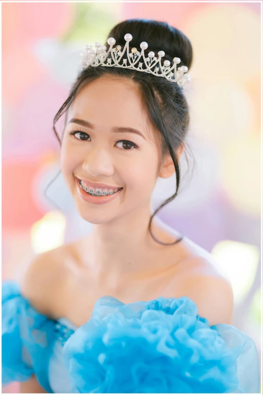 a girl smiling with a tiara on her head