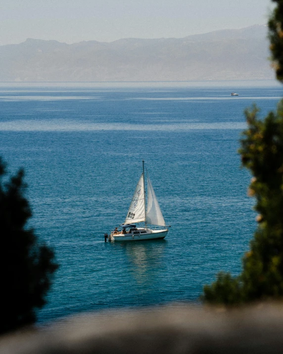 a sailboat floating on top of a blue lake
