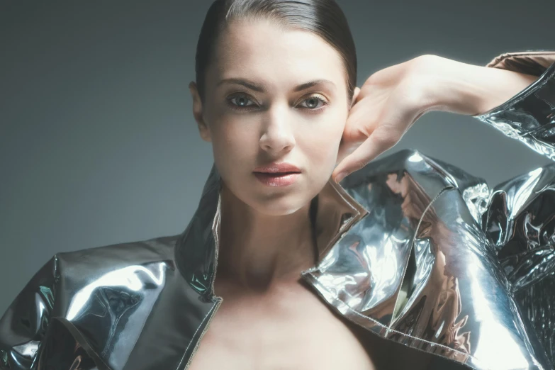 a woman is shown posing with a shiny jacket on her