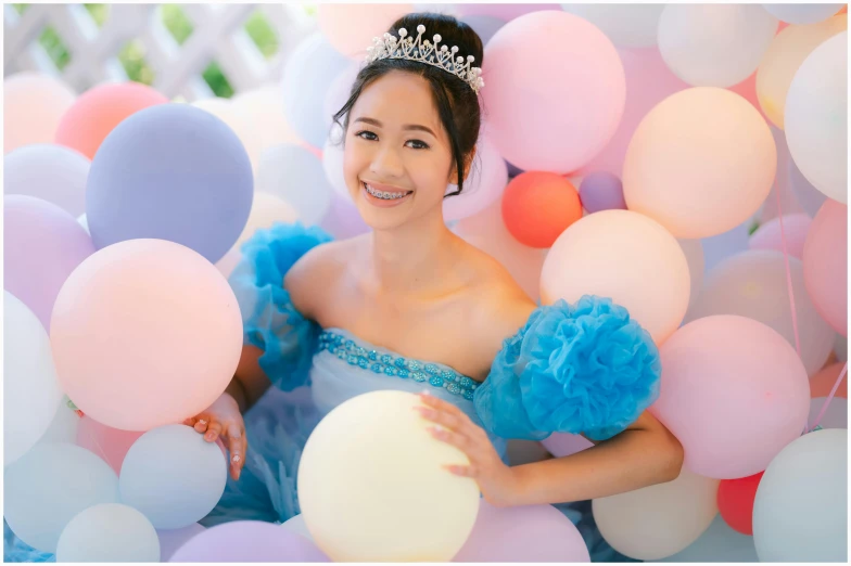 a young lady in a tiara is holding onto balloons