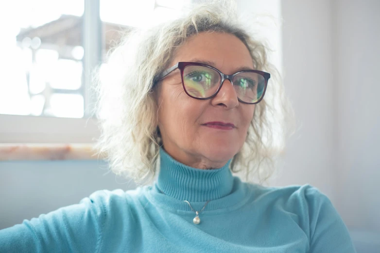 a woman wearing glasses looks at the camera