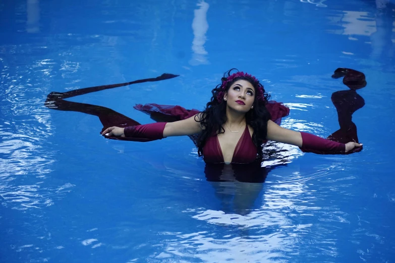 a woman in purple bathing suit and wings in water
