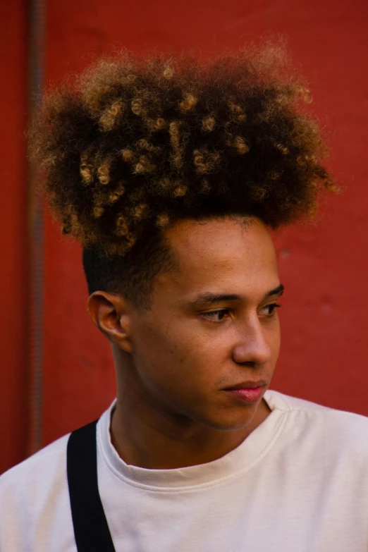 a young man with a short black suspender and afro