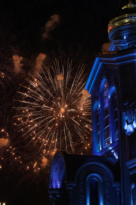 a night view of fireworks and buildings with lights